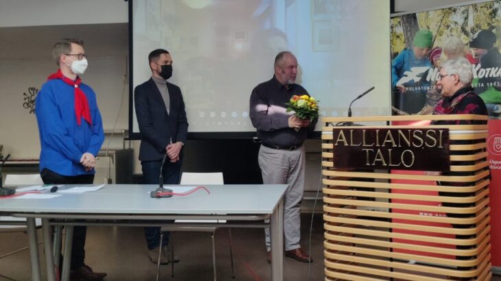 Nuorten Kotkien puheenjohtajiston jäsenet luovuttamassa kukkia Merja Korhoselle